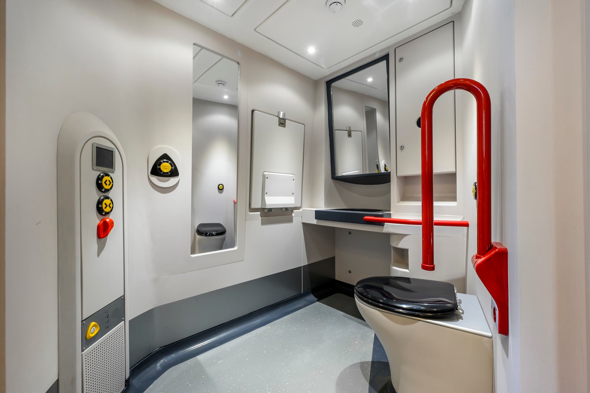 Módulo de aseo PMR del proyecto LNER, con lavabo, inodoro, espejo y barra de apoyo roja.