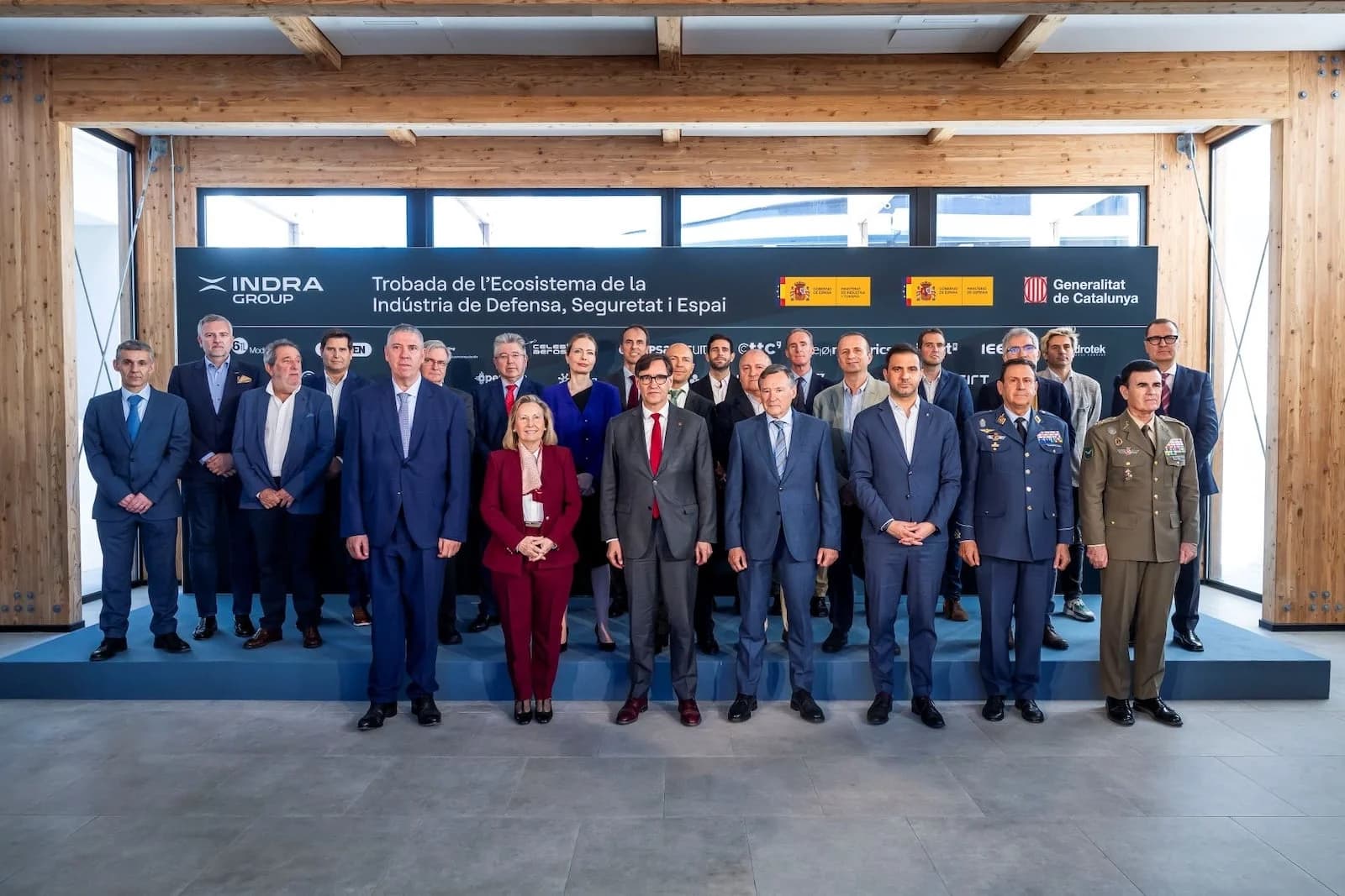 Foto de familia del IV Encuentro del Ecosistema de la Industria Nacional de Defensa, con el panel de Indra Group al fondo.